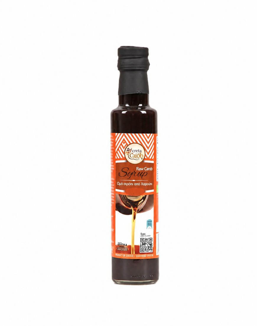 „Creta Carob Raw“ karobų sirupas stikliniame butelyje.